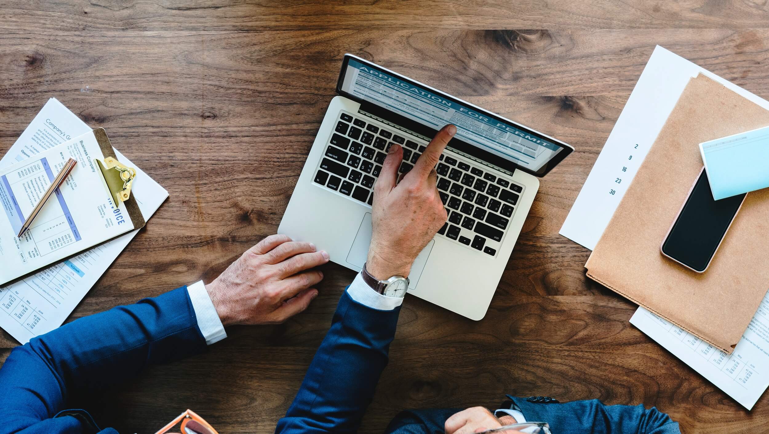 購入した営業リストをパソコンで確認し、書類と突き合わせながら当たり先を整理している様子